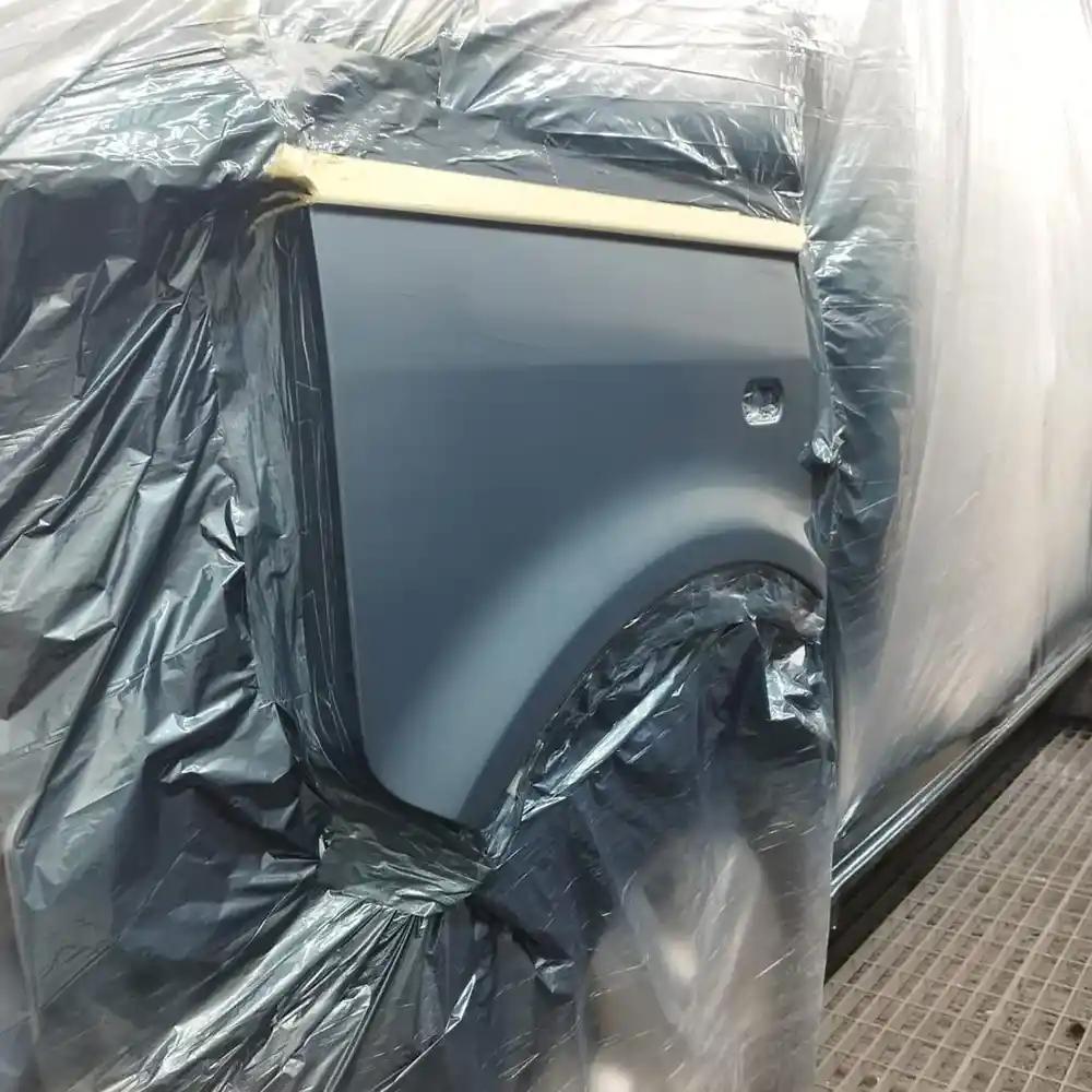 Van respray preparation showing masking and protective covering before spray painting in a professional workshop